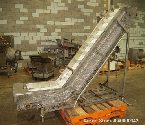 Used Inclined "S" Shaped Conveyor, 304 stainless steel frame. 14" wide x 3" tall cleated plastic belt, 24" long bottom infeed section, 72" long incline section, 12" long top discharge section, approx...