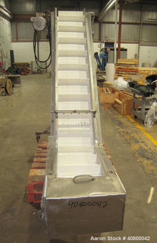 Used Inclined "S" Shaped Conveyor, 304 stainless steel frame. 14" wide x 3" tall cleated plastic belt, 24" long bottom infeed section, 72" long incline section, 12" long top discharge section, approx...