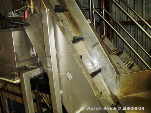 Used Inclined Plastic Belt Conveyor. 18" wide x 96" long with 9" wide x 3" tall off set pockets. 301 stainless steel supply feed hopper, 64" wide x 56" long x approximately 56" deep. Driven by an app...