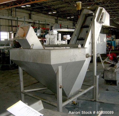 Used Inclined Plastic Belt Conveyor. 18" wide x 96" long with 9" wide x 3" tall offset pockets. 301 stainless steel supply feed hopper, 64" wide x 56" long x approximately 56" deep. Driven by an appr...