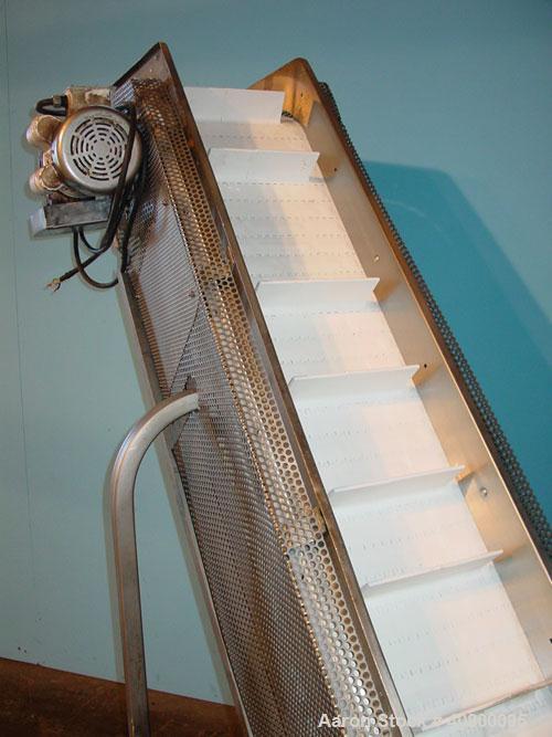 Used Inclined "S" Shaped Conveyor, 304 stainless steel frame. 12" wide x 3" tall cleated plastic belt, 24" long bottom infeed section, 72" long incline section, 12" long top discharge section, approx...