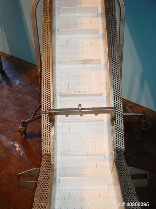 Used Inclined "S" Shaped Conveyor, 304 stainless steel frame. 12" wide x 3" tall cleated plastic belt, 24" long bottom infeed section, 72" long incline section, 12" long top discharge section, approx...