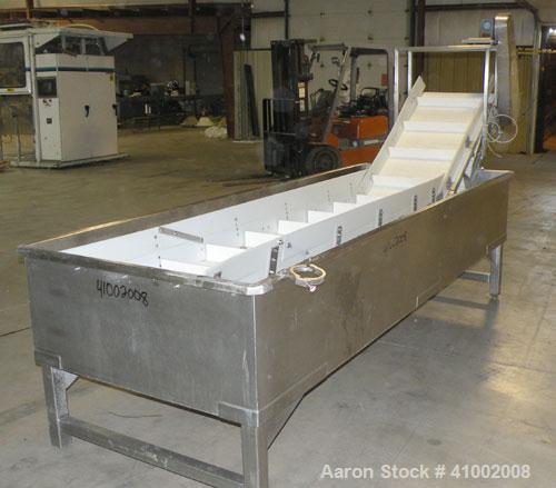Used Inclined Plastic Submerged Belt Conveyor, 304 Stainless Steel. 24" wide x 90" long submerged section x 48" long incline section, 11 7/8" wide x 3" tall pockets. Bottom holding tank 42" wide x 12...