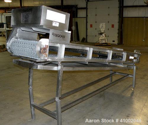 Used Ron Bichel Inclined Plastic Belt Conveyor. 24" wide x 116" long with 11 1/2" wide x 1/2" tall pockets. Driven by a 3/4 hp, 3/60/208-230/460 volt, 1750 rpm motor thru a reducer, ratio 20 to 1. 54...
