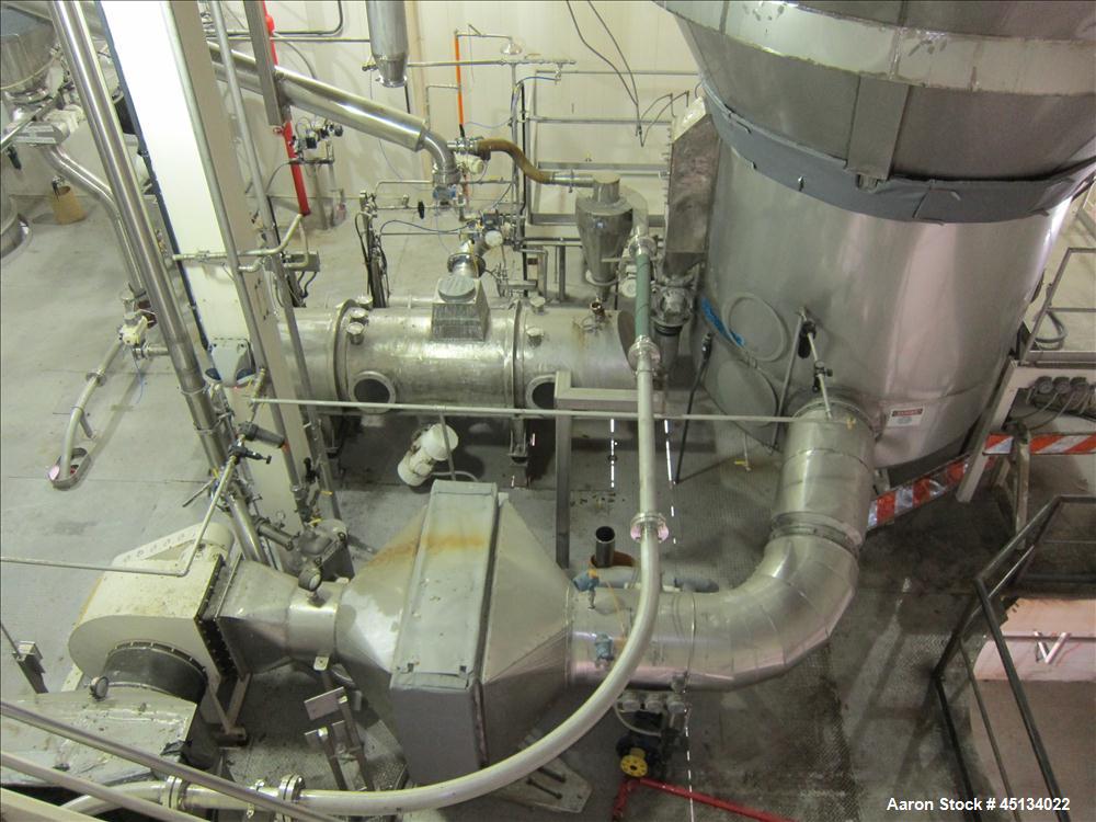 Used Niro Spray Tower Dryer. Originally designed for 12,500 pounds / hour of water evaporation. The dryer capacity was increased to 15,000 pounds / hour at 65,000 SCFM of air flow.  The Dryer is constructed of 316 L Stainless Steel. The dryer is a Standard Tall Form Dryer equipped with an integral static Fluid Bed Dryer and external Vibratory Fluid Bed Cooler. Both beds have heaters and the VFB also had a Cooler. The Dryer was equipped with fines return and agglomeration capabilities as an opti