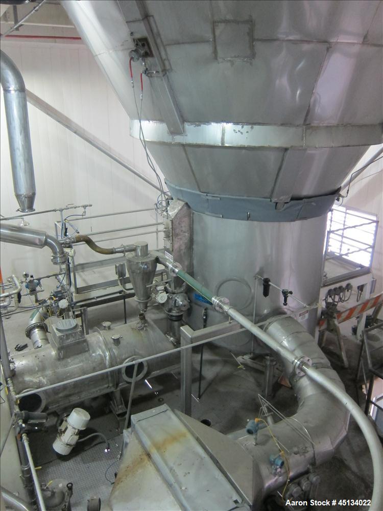 Used Niro Spray Tower Dryer. Originally designed for 12,500 pounds / hour of water evaporation. The dryer capacity was increased to 15,000 pounds / hour at 65,000 SCFM of air flow.  The Dryer is constructed of 316 L Stainless Steel. The dryer is a Standard Tall Form Dryer equipped with an integral static Fluid Bed Dryer and external Vibratory Fluid Bed Cooler. Both beds have heaters and the VFB also had a Cooler. The Dryer was equipped with fines return and agglomeration capabilities as an opti
