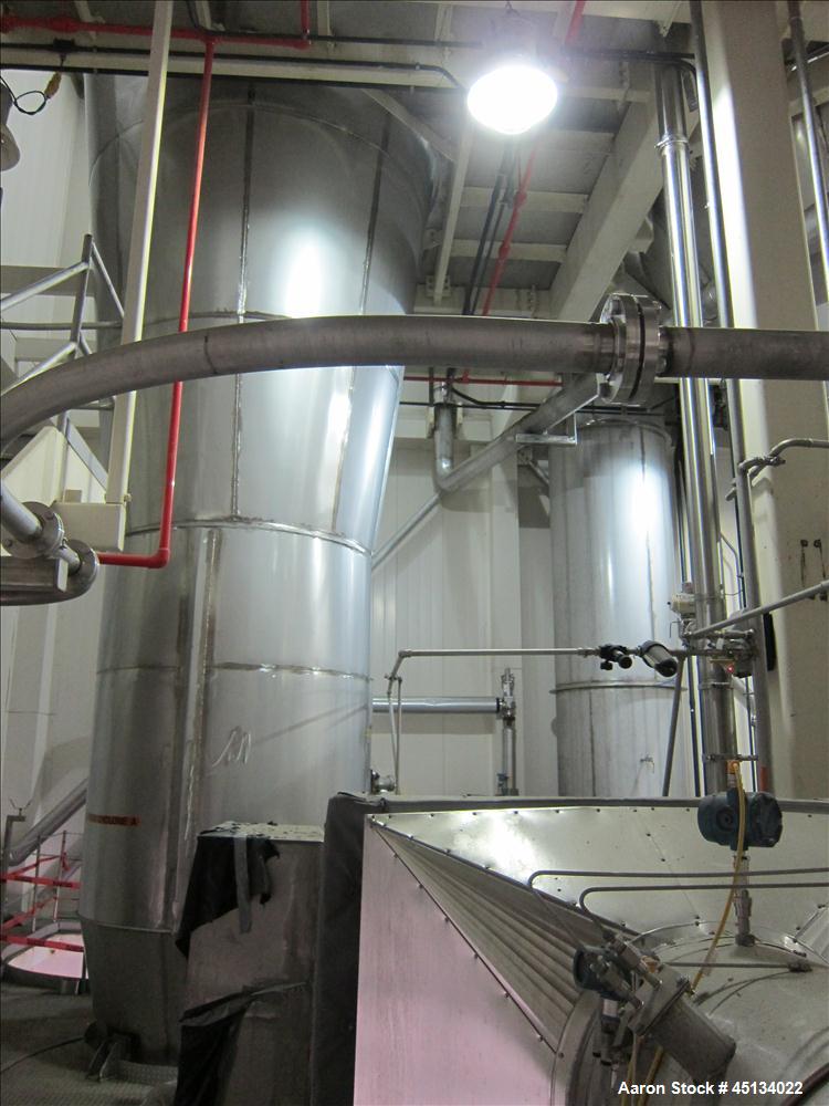 Used Niro Spray Tower Dryer. Originally designed for 12,500 pounds / hour of water evaporation. The dryer capacity was increased to 15,000 pounds / hour at 65,000 SCFM of air flow.  The Dryer is constructed of 316 L Stainless Steel. The dryer is a Standard Tall Form Dryer equipped with an integral static Fluid Bed Dryer and external Vibratory Fluid Bed Cooler. Both beds have heaters and the VFB also had a Cooler. The Dryer was equipped with fines return and agglomeration capabilities as an opti