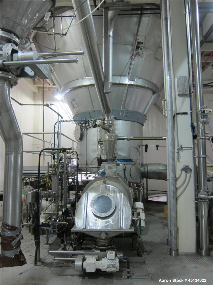 Used Niro Spray Tower Dryer. Originally designed for 12,500 pounds / hour of water evaporation. The dryer capacity was increased to 15,000 pounds / hour at 65,000 SCFM of air flow.  The Dryer is constructed of 316 L Stainless Steel. The dryer is a Standard Tall Form Dryer equipped with an integral static Fluid Bed Dryer and external Vibratory Fluid Bed Cooler. Both beds have heaters and the VFB also had a Cooler. The Dryer was equipped with fines return and agglomeration capabilities as an opti