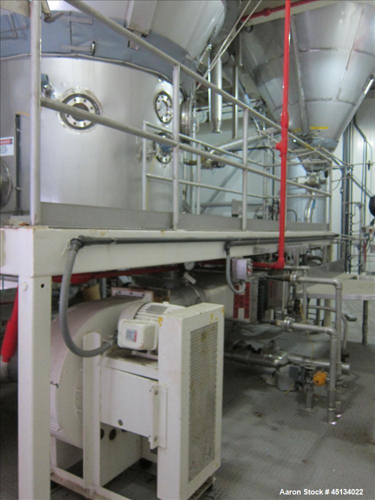 Used Niro Spray Tower Dryer. Originally designed for 12,500 pounds / hour of water evaporation. The dryer capacity was increased to 15,000 pounds / hour at 65,000 SCFM of air flow.  The Dryer is constructed of 316 L Stainless Steel. The dryer is a Standard Tall Form Dryer equipped with an integral static Fluid Bed Dryer and external Vibratory Fluid Bed Cooler. Both beds have heaters and the VFB also had a Cooler. The Dryer was equipped with fines return and agglomeration capabilities as an opti