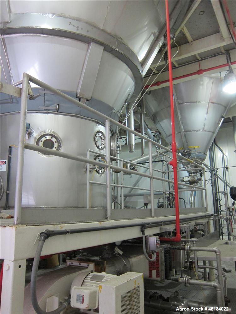 Used Niro Spray Tower Dryer. Originally designed for 12,500 pounds / hour of water evaporation. The dryer capacity was increased to 15,000 pounds / hour at 65,000 SCFM of air flow.  The Dryer is constructed of 316 L Stainless Steel. The dryer is a Standard Tall Form Dryer equipped with an integral static Fluid Bed Dryer and external Vibratory Fluid Bed Cooler. Both beds have heaters and the VFB also had a Cooler. The Dryer was equipped with fines return and agglomeration capabilities as an opti