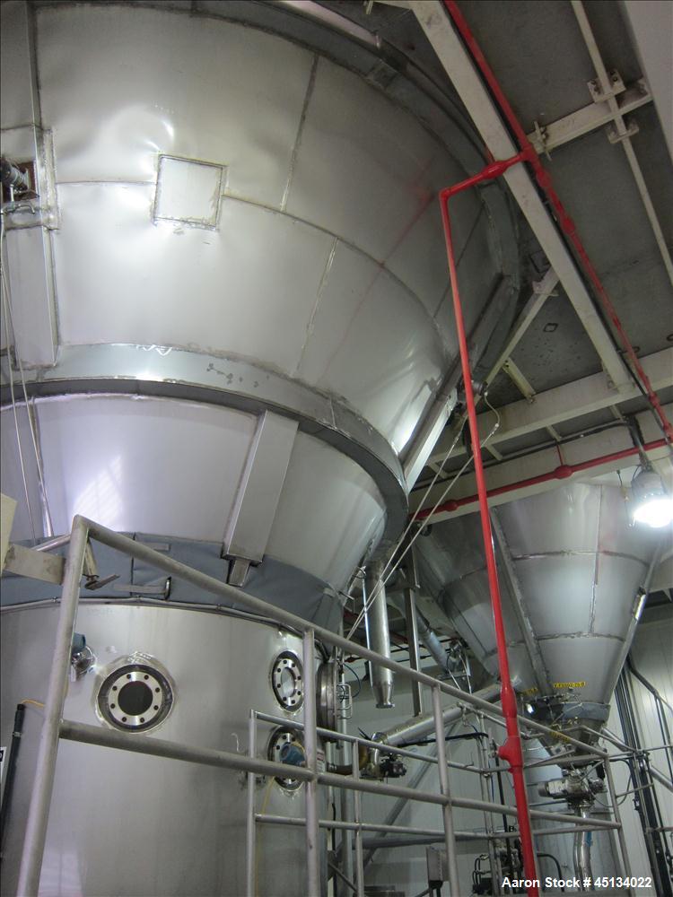 Used Niro Spray Tower Dryer. Originally designed for 12,500 pounds / hour of water evaporation. The dryer capacity was increased to 15,000 pounds / hour at 65,000 SCFM of air flow.  The Dryer is constructed of 316 L Stainless Steel. The dryer is a Standard Tall Form Dryer equipped with an integral static Fluid Bed Dryer and external Vibratory Fluid Bed Cooler. Both beds have heaters and the VFB also had a Cooler. The Dryer was equipped with fines return and agglomeration capabilities as an opti