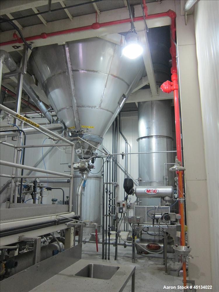 Used Niro Spray Tower Dryer. Originally designed for 12,500 pounds / hour of water evaporation. The dryer capacity was increased to 15,000 pounds / hour at 65,000 SCFM of air flow.  The Dryer is constructed of 316 L Stainless Steel. The dryer is a Standard Tall Form Dryer equipped with an integral static Fluid Bed Dryer and external Vibratory Fluid Bed Cooler. Both beds have heaters and the VFB also had a Cooler. The Dryer was equipped with fines return and agglomeration capabilities as an opti
