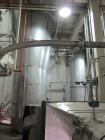 Used Niro Spray Tower Dryer. Originally designed for 12,500 pounds / hour of water evaporation. The dryer capacity was increased to 15,000 pounds / hour at 65,000 SCFM of air flow.  The Dryer is constructed of 316 L Stainless Steel. The dryer is a Standard Tall Form Dryer equipped with an integral static Fluid Bed Dryer and external Vibratory Fluid Bed Cooler. Both beds have heaters and the VFB also had a Cooler. The Dryer was equipped with fines return and agglomeration capabilities as an opti