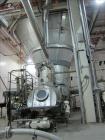 Used Niro Spray Tower Dryer. Originally designed for 12,500 pounds / hour of water evaporation. The dryer capacity was increased to 15,000 pounds / hour at 65,000 SCFM of air flow.  The Dryer is constructed of 316 L Stainless Steel. The dryer is a Standard Tall Form Dryer equipped with an integral static Fluid Bed Dryer and external Vibratory Fluid Bed Cooler. Both beds have heaters and the VFB also had a Cooler. The Dryer was equipped with fines return and agglomeration capabilities as an opti