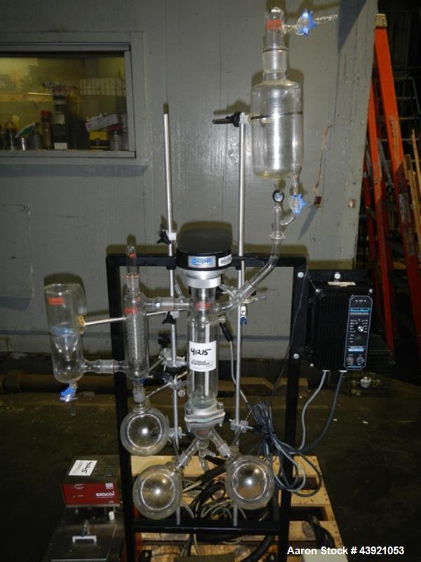 Used Pope Scientific Wiped Film Evaporator, 0.35 Square Feet. 2" Diameter glass chamber, stainless steel rotor with Teflon wipers driven by 1/12 hp dc motor with controller, glass coil condenser with...