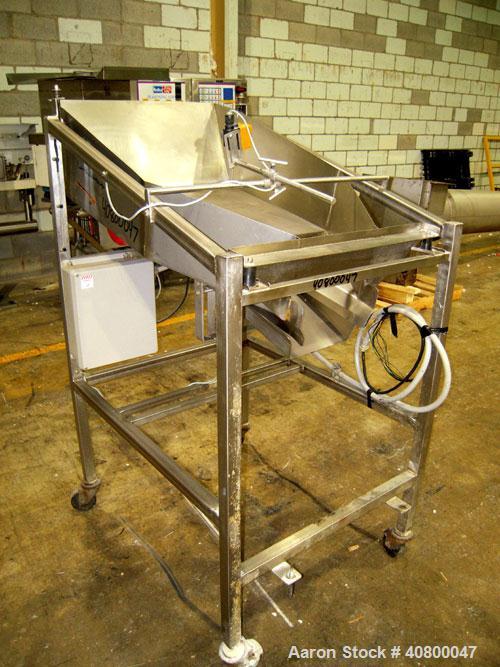 Used Vibratory Feeder, stainless steel. 26" wide x 42" long x 10" deep tray. Mounted on a stainless steel frame with casters.