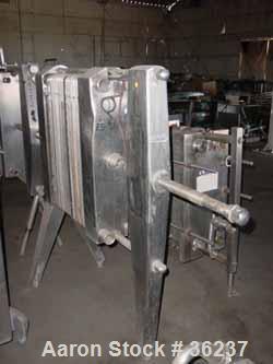 Used APV Plate Heat Exchanger, Model HX, Stainless Steel. Approximately 70 square feet. (54) 9" wide x 34" long plates. 24-1/2" open rail, 1 type tightening bar. (4) 2" bevel seal inlets/outlets.