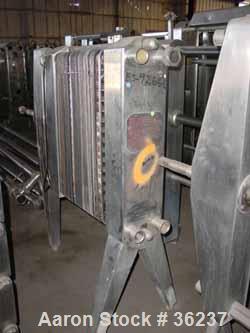 Used APV Plate Heat Exchanger, Model HX, Stainless Steel. Approximately 70 square feet. (54) 9" wide x 34" long plates. 24-1/2" open rail, 1 type tightening bar. (4) 2" bevel seal inlets/outlets.