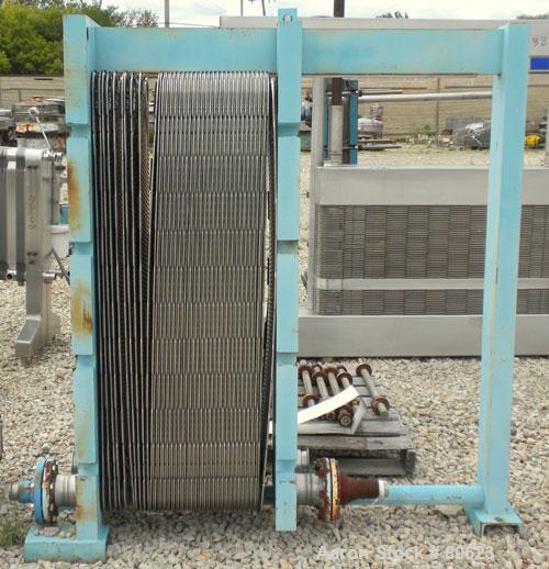 Used APV Plate Heat Exchanger, Approximately 878 Square Feet, Model R57, 316 Stainless Steel. (61) 16" wide x 60" tall plates, (2) 4-1/2" fittings, (2) 4" sanitary fittings. Mounted in a carbon steel...