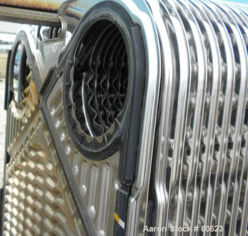 Used APV Plate Heat Exchanger, Approximately 878 Square Feet, Model R57, 316 Stainless Steel. (61) 16" wide x 60" tall plates, (2) 4-1/2" fittings, (2) 4" sanitary fittings. Mounted in a carbon steel...