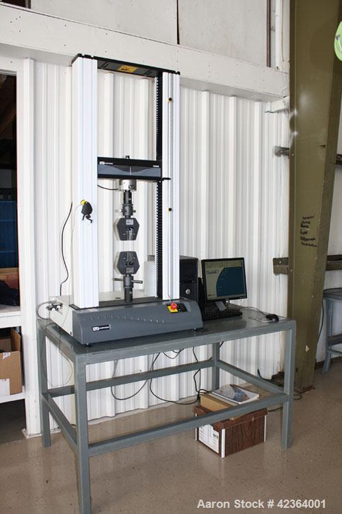 Used Instron 3369 Materials Testing Load Frame. Includes the following accessories:  Model 2630-114 strain gauge extensometer; model 2716-002 wedge action grips; model 2703-006 faces, flat serrated; ...