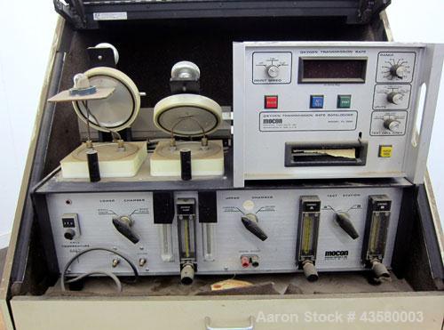 Used Mocon Ox-Tran Twin Oxygen Permeation Measuring Machine, Part# 001-050. Includes a Mocon oxygen transmission rate datalogger, model DL-200, part# 140-029, serial# 0588519, and a Jensen sound cabi...
