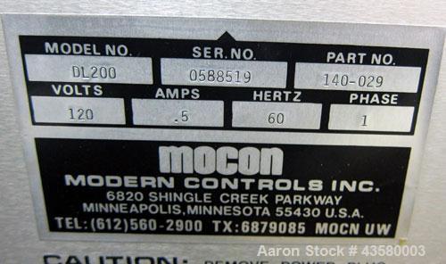 Used Mocon Ox-Tran Twin Oxygen Permeation Measuring Machine, Part# 001-050. Includes a Mocon oxygen transmission rate datalogger, model DL-200, part# 140-029, serial# 0588519, and a Jensen sound cabi...