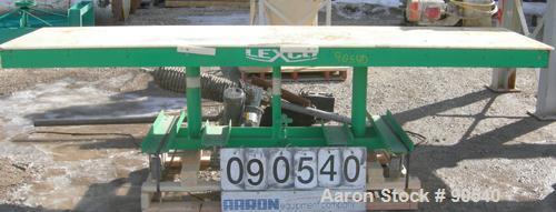 Used: Lexco long deck hydraulic lift table, model STN3010-2F, carbon steel. Approximately 2000 pound lift capacity, 30" wide x 10' long table. Foot pedal lift. Mounted on casters.