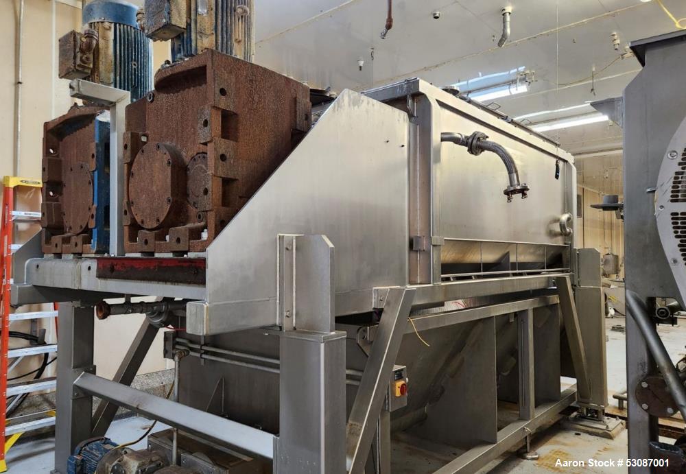 Used Karl Schnell Paddle Mixer, Stainless Steel. Approximately 140 cubic feet, 4000 Liter capacity. Has stainless steel feed hopper with dual screw conveyors, driven by (2) Approximate 5.4HP drive ge...