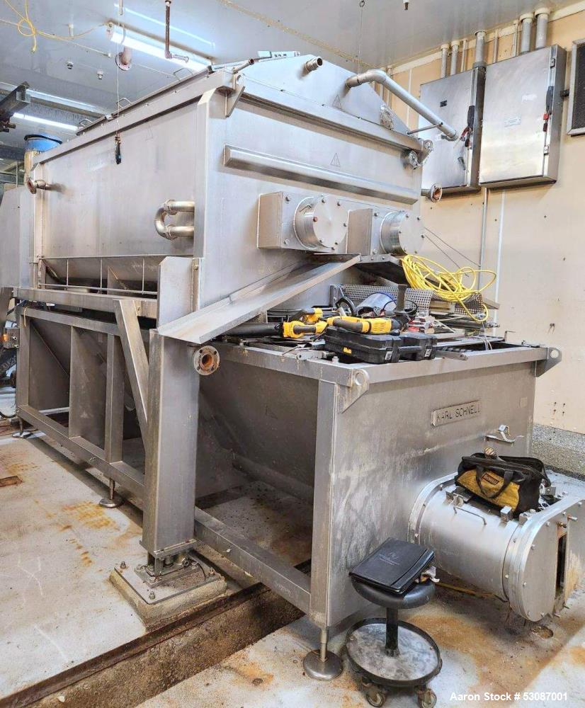 Used Karl Schnell Paddle Mixer, Stainless Steel. Approximately 140 cubic feet, 4000 Liter capacity. Has stainless steel feed hopper with dual screw conveyors, driven by (2) Approximate 5.4HP drive ge...
