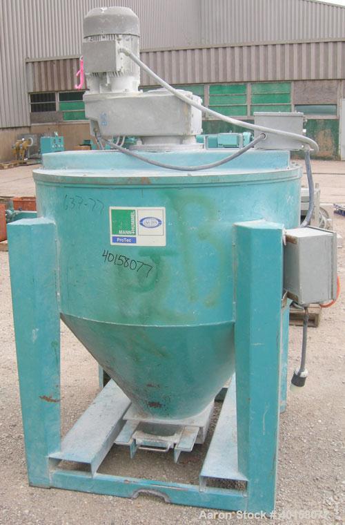 Used Universal Dynamics Vertical Ribbon Mixer, approximately 26 cubic feet, model 65-2000, carbon steel. 48" diameter x 22" straight side x 30" coned bottom. 3" diameter shaft, single ribbon 1 3/4" w...