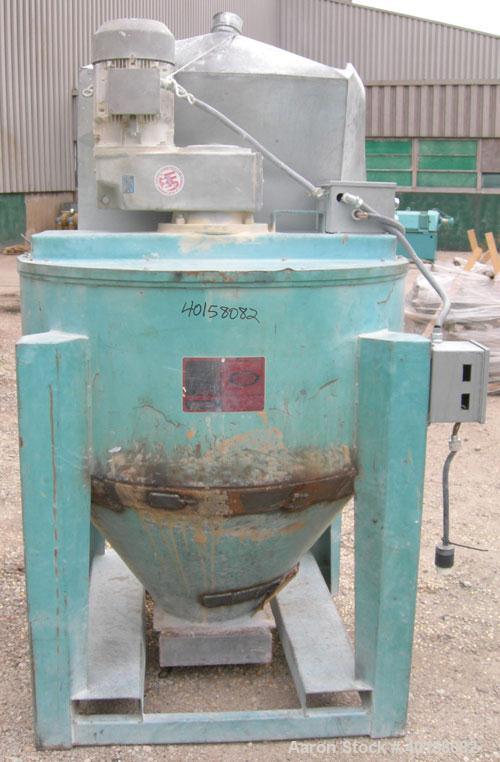 Used Universal Dynamics Vertical Ribbon Mixer, approximately 26 cubic feet, model 65-2000, carbon steel. 48" diameter x 22" straight side x 30" coned bottom. 3" diameter shaft, single ribbon 1 3/4" w...