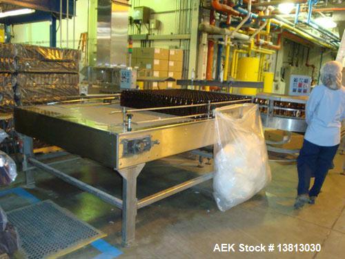 Used Seco stainless steel manual debagging table with 90" x 64" packoff area.
