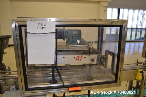 Used Fragrance Overlid snap capper. Unit was designed with top compression belt to gradually snap on overlids or caps to Fragrance containers. Last used in a complete MRM Elgin fragrance filling line.