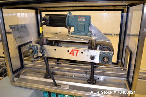 Used Fragrance Overlid snap capper. Unit was designed with top compression belt to gradually snap on overlids or caps to Fragrance containers. Last used in a complete MRM Elgin fragrance filling line.