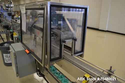 Used Fragrance Overlid snap capper. Unit was designed with top compression belt to gradually snap on overlids or caps to Fragrance containers. Last used in a complete MRM Elgin fragrance filling line.
