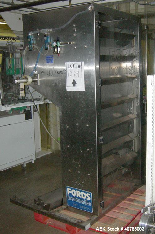 Used Fords Holmatic Lid Feeder, Model SM 3000. 34 1/2" long x 6" wide x approximately 3" deep stainless steel buckets. Driven by a variable speed motor. 1/60/120 volt, 12.5 amps, 10 cfm, 80 psi.