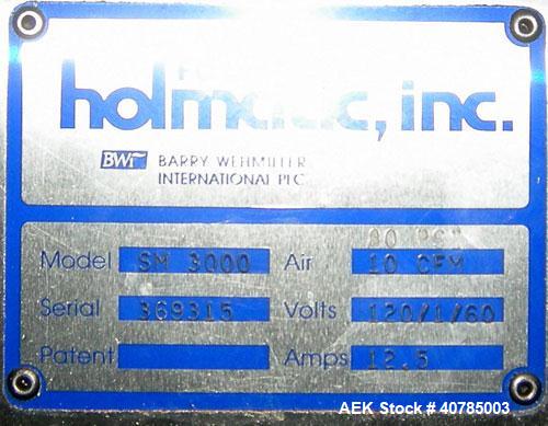 Used Fords Holmatic Lid Feeder, Model SM 3000. 34 1/2" long x 6" wide x approximately 3" deep stainless steel buckets. Driven by a variable speed motor. 1/60/120 volt, 12.5 amps, 10 cfm, 80 psi.