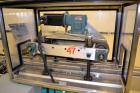 Used Fragrance Overlid snap capper. Unit was designed with top compression belt to gradually snap on overlids or caps to Fragrance containers. Last used in a complete MRM Elgin fragrance filling line.