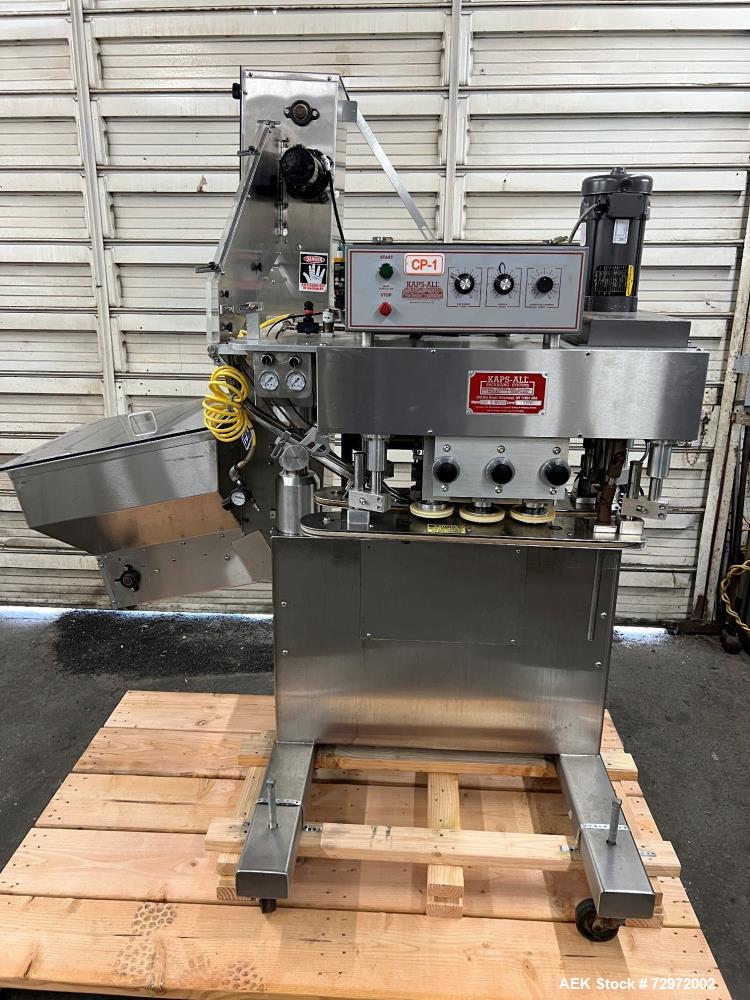 Used Kapsall Model A2 Inline Screw Capper. Capable of speeds up to 150 bottles per minute. Has single bottle grippers, three pair spindles  with adjustable cap chute and integrated cap elevator. Cap ...