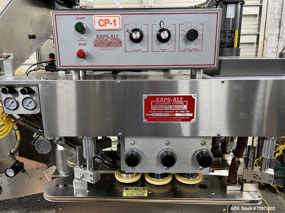 Used Kapsall Model A2 Inline Screw Capper. Capable of speeds up to 150 bottles per minute. Has single bottle grippers, three pair spindles  with adjustable cap chute and integrated cap elevator. Cap ...