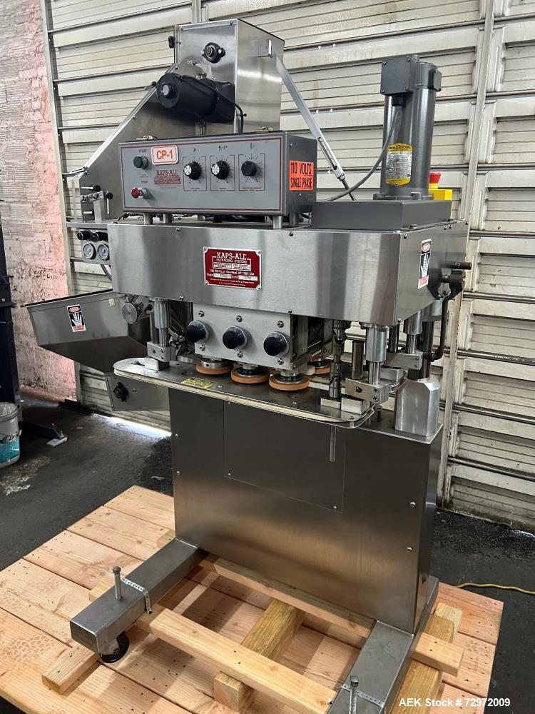 Used Kapsall Model A 2Inline Screw Capper. Capable of speeds up to 150 bottles per minute. Has single bottle grippers, three pair spindles  with adjustable cap chute and integrated cap elevator. Cap ...