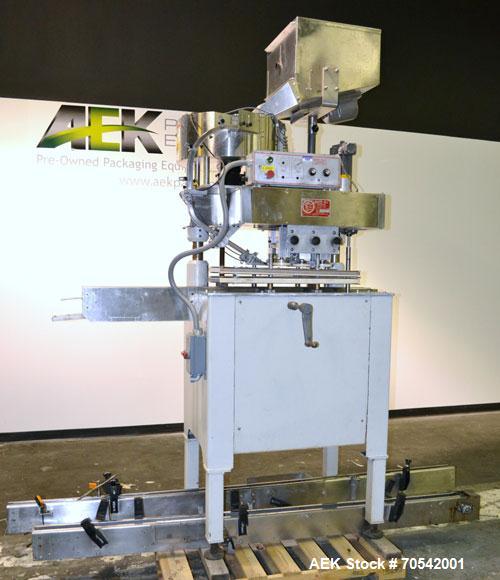 Used Kapsall Model A Inline Screw Capper. Capable of speeds up to 200 bottles per minute. Has dual bottle grippers, three pair spindles and 24" dia centrifigal cap sorter with adjustable cap chute. C...