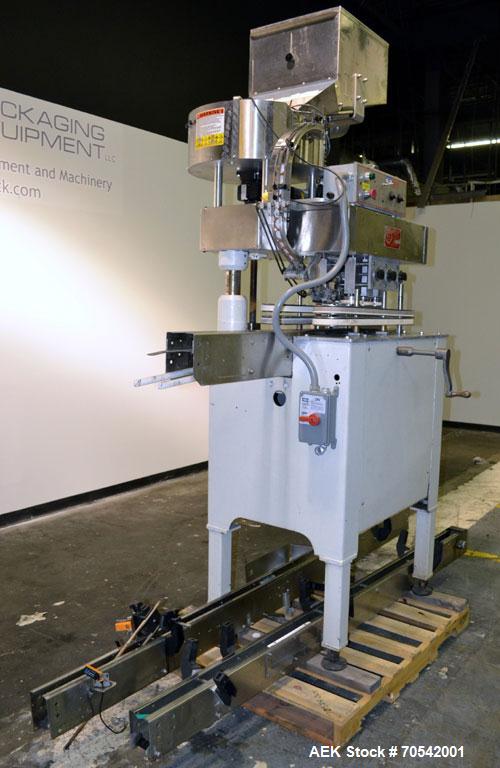 Used Kapsall Model A Inline Screw Capper. Capable of speeds up to 200 bottles per minute. Has dual bottle grippers, three pair spindles and 24" dia centrifigal cap sorter with adjustable cap chute. C...
