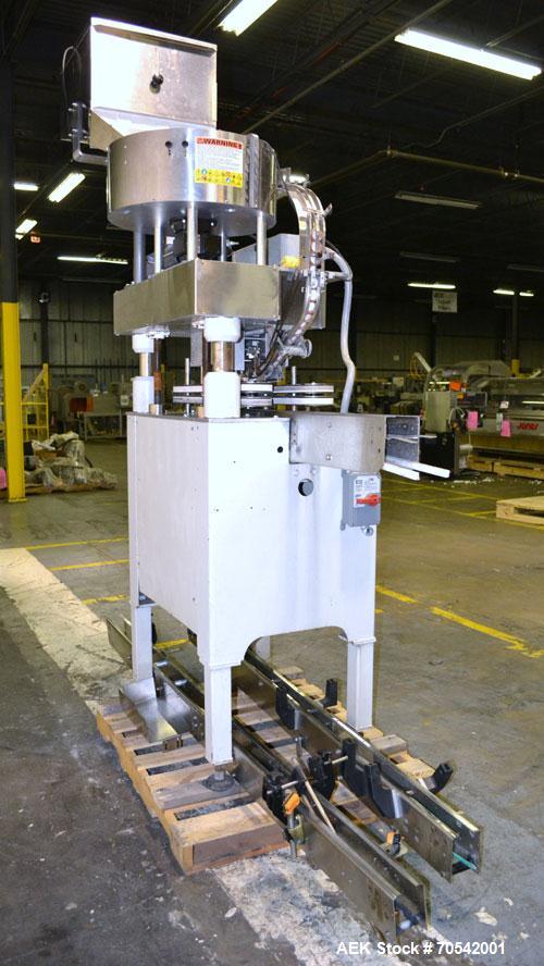 Used Kapsall Model A Inline Screw Capper. Capable of speeds up to 200 bottles per minute. Has dual bottle grippers, three pair spindles and 24" dia centrifigal cap sorter with adjustable cap chute. C...
