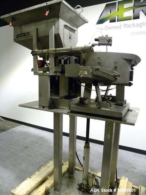 Used SureKap Fully Automatic Straight Line Six Spindle Quill Capper, Model SK6000-SP. Capacities 100 bottles per minute depending on size and conveyor speed. Cap Size Range: diameter 8mm to 110mm (Ma...