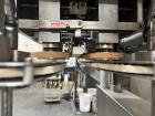 Used Kapsall Model A 2Inline Screw Capper. Capable of speeds up to 150 bottles per minute. Has single bottle grippers, three pair spindles  with adjustable cap chute and integrated cap elevator. Cap ...