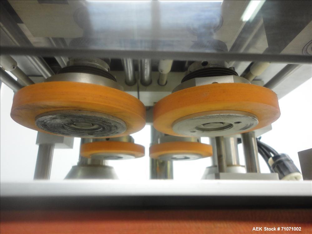 Used D.L.Tech (Aesus) Model DLCAP-2E Cap Retorquer. Machine is capable of speeds from 0 - 120 containers per minute.  Single belt gripper container handling. C frame design--rolls right up to an exis...