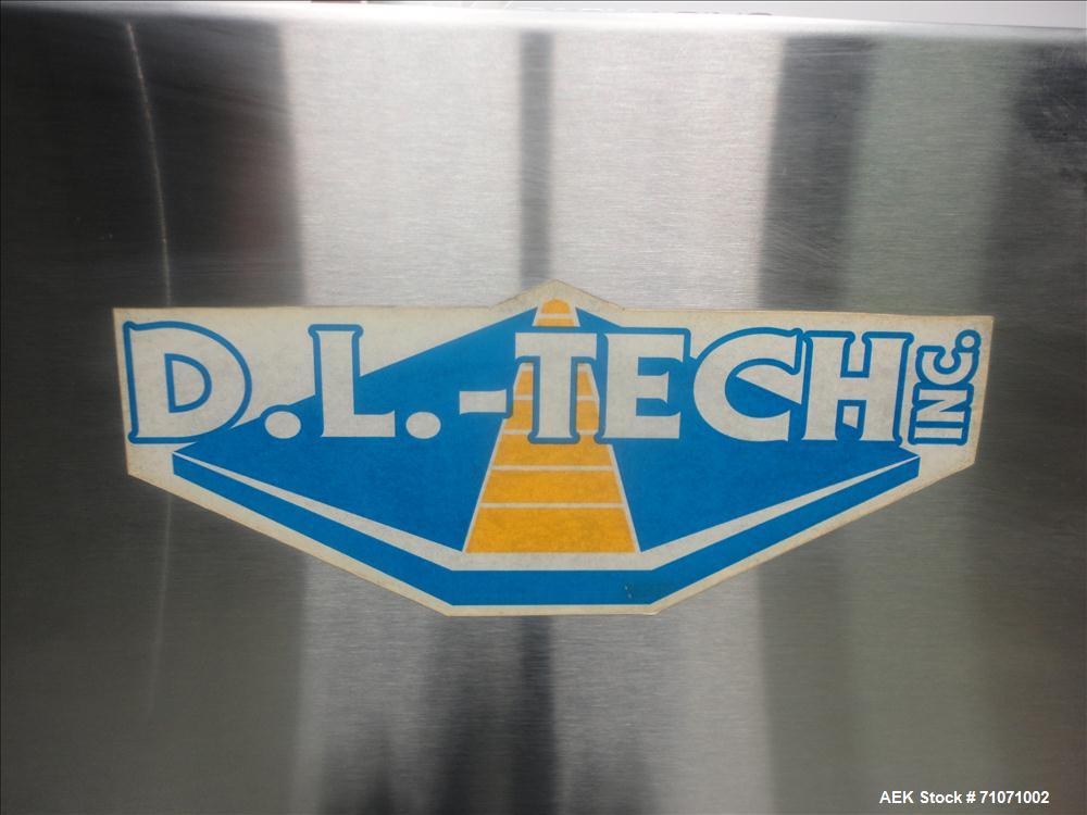 Used D.L.Tech (Aesus) Model DLCAP-2E Cap Retorquer. Machine is capable of speeds from 0 - 120 containers per minute.  Single belt gripper container handling. C frame design--rolls right up to an exis...