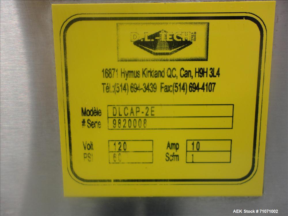 Used D.L.Tech (Aesus) Model DLCAP-2E Cap Retorquer. Machine is capable of speeds from 0 - 120 containers per minute.  Single belt gripper container handling. C frame design--rolls right up to an exis...